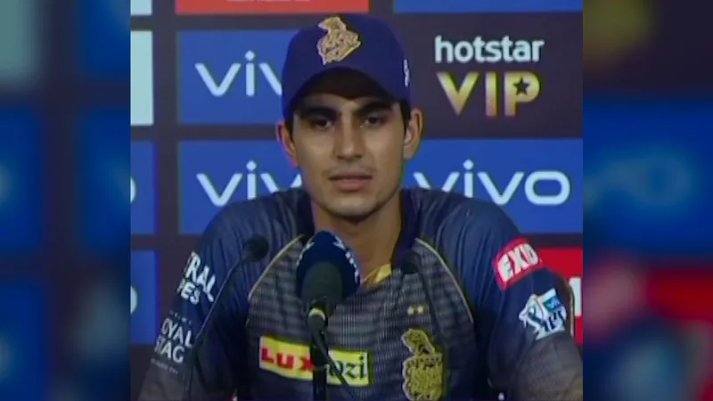 Shubman Gill seated at a press conference microphone